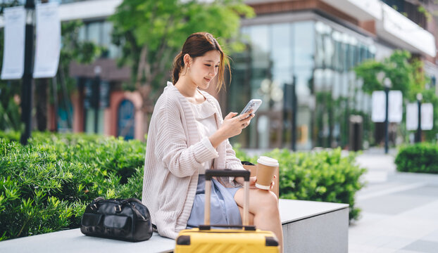Young adult asian business woman using smartphone texting message work and travel on the go urban lifestyle