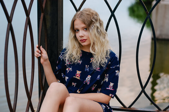 beautiful pretty teenager girl sitting near the fence, portrait, face