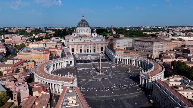 Elliptical Piazza San Pietro, central obelisk, and St. Peter's Basilica stand above the surrounding city in a bright midday aerial flyover.