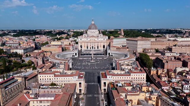 St. Peter's Basilica and Piazza San Pietro align with the long city avenue on a clear daytime aerial push.