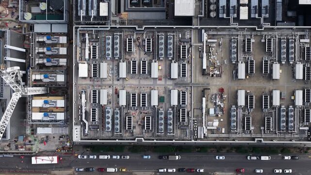 Aerial top down perspective capturing the expansive rooftop of a modern datacenter, revealing intricate cooling systems and infrastructure vital for big data processing and cloud computing