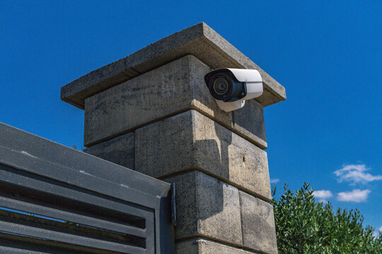 Video surveillance camera installed above the entrance gate to a luxury villa by the sea, security camera, fine for recording video and audio in a public place,