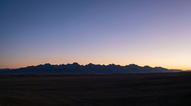 Vast Mountain Range Silhouetted Against a Colorful Twilight Sky.