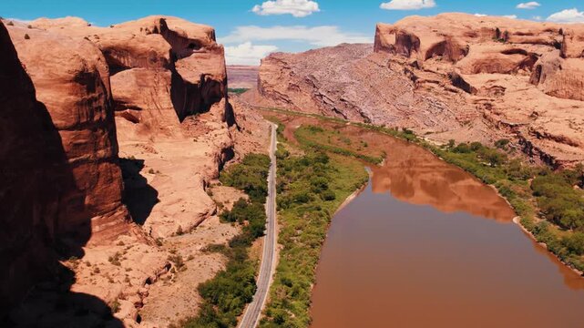 Wall Street near Moab, Utah from a drone aerial view showing red rock cliffs and Colorado River below.