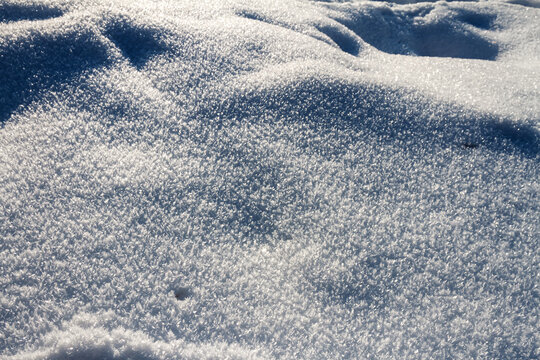 Natural winter backdrop featuring white snow texture. Winter white snow surface as background.