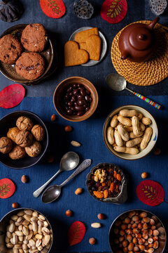 Food themed still life with crockery, various nuts and tea. Flat lay. Top view.