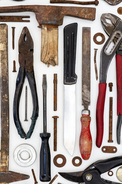 Flat lay of old hand tools on white background. Large collection of various rusty tools and bits arranged on white.