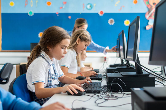 Teacher supervising students during computer class at school