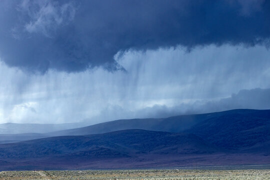 Storm clouds and rain above hills
