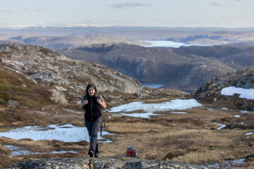 Obraz premium Woman hiking on mountain Oretoppen ( norwegian Øretoppen ) on South Varanger, in Finnmark County, Norway