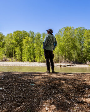 Rear view of man standing near river in forest
