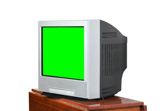 An old green screen television sits on a vintage 1990s/1980s nightstand against a white background.