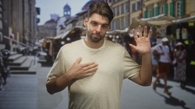 Hispanic man with beard placing hand on chest and raising other palm in a pledge gesture amid a busy outdoor market street; apologetic sincerity.