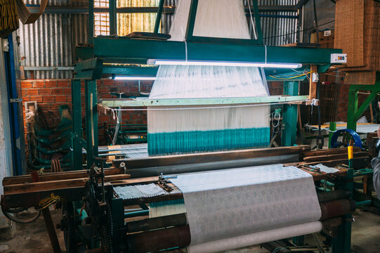 a silk thread weaving machine at a silk factory in Asia in Vietnam