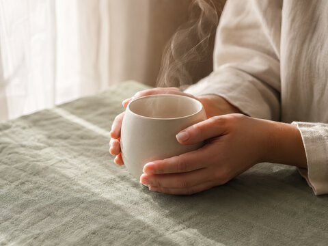 A person enjoys a hot beverage in a serene and comfortable setting, capturing a moment of relaxation and warmth.