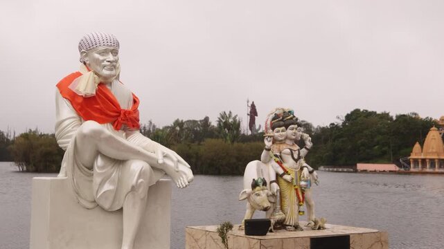 White statues of Hindu deities decorating the shore of the sacred crater lake at Ganga Talao temple complex in Mauritius. Spiritual pilgrimage site at Grand Bassin