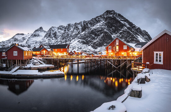 Red wooden fishing village of A in last sunlight in arctic fjord