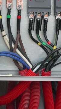 Electricity wiring power, close up of heavy duty cables and copper busbars inside an industrial electrical switchboard panel.