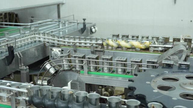 Canned food production line in a modern automated factory, Metal cans moving on conveyor belt in canning facility, Industrial food packaging process with automated metal can conveyor