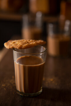 Close up of a glass filled with tea kept on a table with matthi on top of it