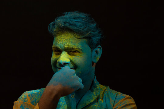 Man smiling with gulal on his face and mischief on his mind