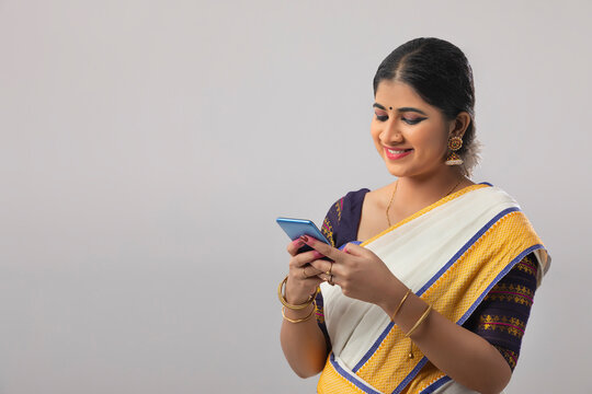 Indian classical dancer smiling while texting on her phone