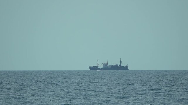 Ship ocean seascape. Large ship sails on the vast blue ocean under a clear light blue sky