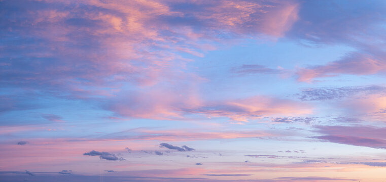 Pale pink clouds against blue sky
