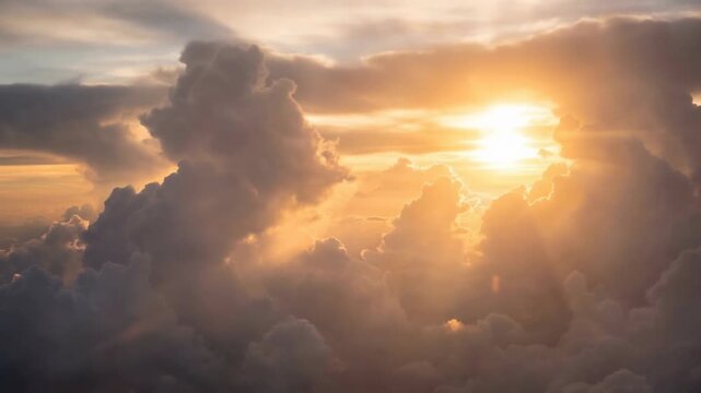 Soft billowy clouds form dreamy flight concept. Stunning golden sunset with dramatic clouds and vibrant sunlight breaking through the sky