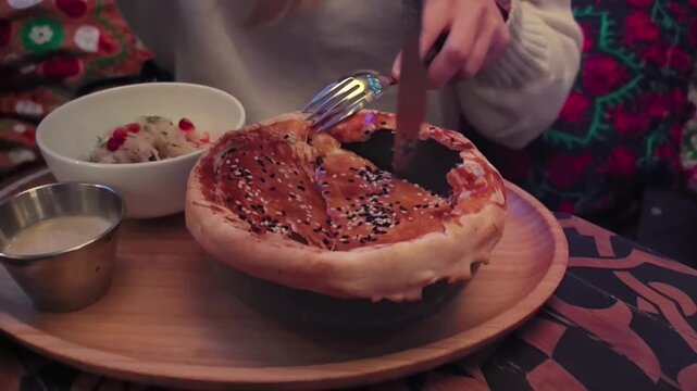 A warm pastry filled with rich flavors is carefully opened at a charming cafe. Tantalizing aromas fill the air as toppings are added, creating a delightful treat to savor.