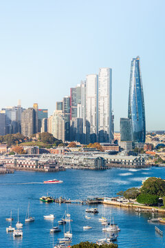 Boats moored in harbor with skyscrapers in background
