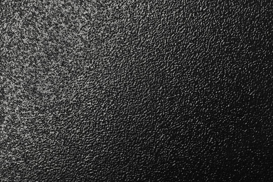 Close-up of a black powder coating textured surface showing rough grain, fine detail and abstract monochrome pattern ideal for backgrounds, design overlays, and industrial or minimalist visual themes