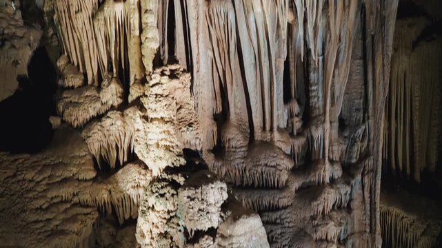 Calcite cave formations reveal layered stalactites and flowstone textures, perfect for geology education, natural history media, karst tourism, and mineral deposition themes.