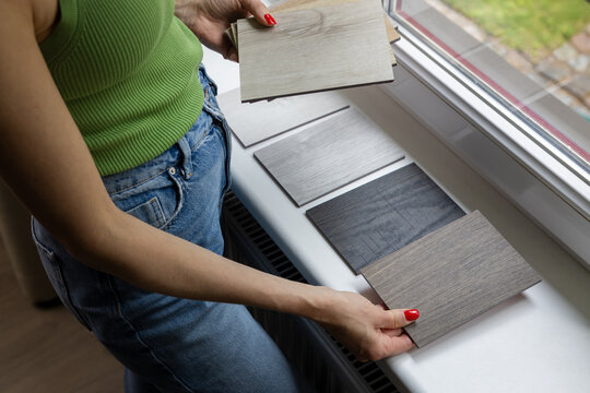 Woman choosing materials from wood samples for  home flooring and furniture. Interior design and renovation