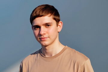 Fototapeta premium Portrait of Caucasian teenage boy looking at camera against plain background, conveying confidence and youth identity. Useful for education, mental health, teen lifestyle campaigns