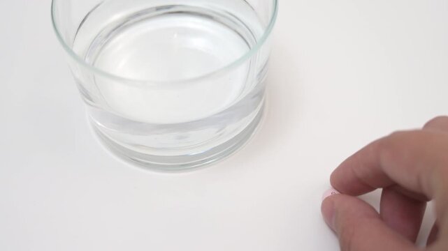 Taking pregnancy medication dosage with a glass of water