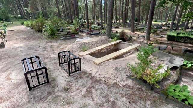 Fresh open grave in a European cemetery before coffin arrival and funeral burial ceremony