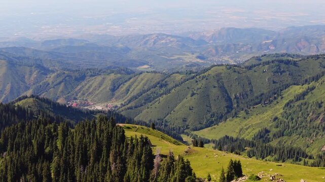 Cinematic aerial flight around camping spot on Kim Asar ridge in Almaty Kazakhstan with the city in the background