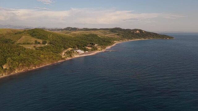 Wide drone view of a quiet beach, forested hills and clear Adriatic Sea along the coast of Kepi i Rodonit, Albania.
