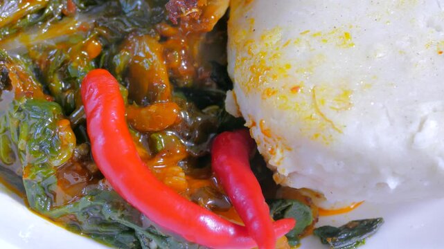 Traditional East African ugali and sukuma wiki with red chili peppers