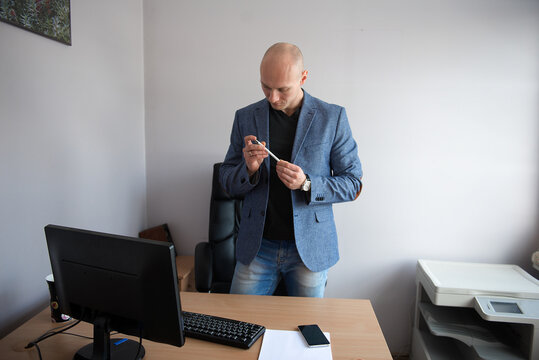 Businessman Checking Smartphone In Office Workplace