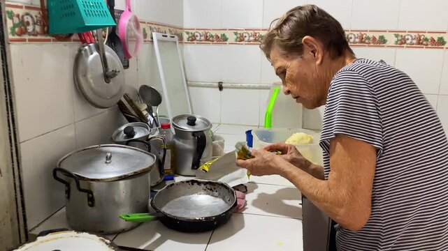 Portrait of a woman Latina cooking traditional corn arepas by hand in a kitchen in Neiva, Huila, Colombia. Concept of raw food and handmade 