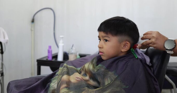 Little asian school boy hair cut in man barber shop beauty fashion