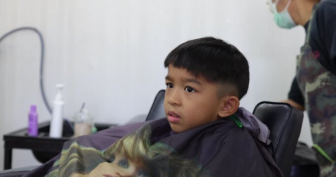 Little asian school boy hair cut in man barber shop beauty fashion