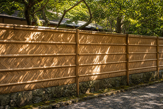 Bamboo fence with dappled sunlight shadow pattern tranquil Japan