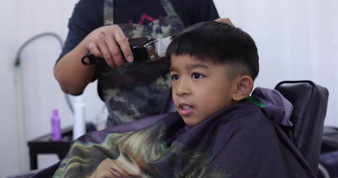 Little asian school boy hair cut in man barber shop beauty fashion