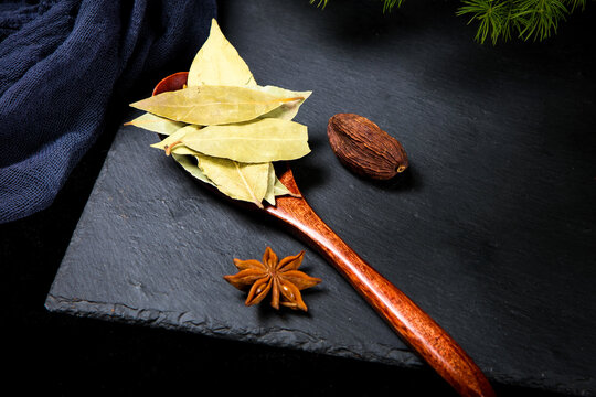 Dried Fragrant Bay Leaves On Wooden Spoon Dark Slate Surface