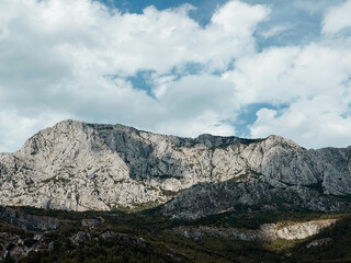 Fototapeta premium Majestic limestone peaks of Biokovo mountain ridge under dramatic sky in Croatia, perfect for hiking