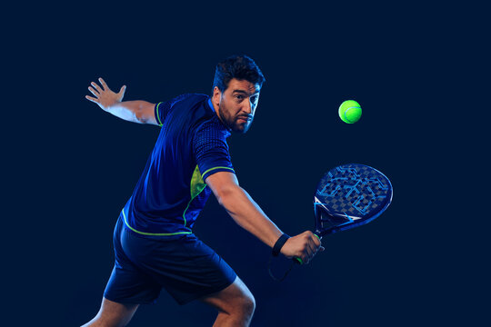 Padel Tennis Player with Racket in Hand. Paddle tenis, on a blue background. Download in high resolution.