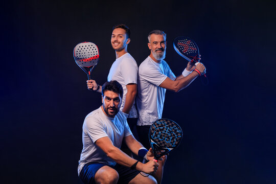 Team of padel tennis player with racket. Men athletes with paddle racket on court with neon colors. Sport concept. Download a high quality photo for the design of a sports app or betting site.